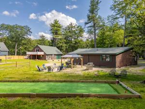 a log home with a golf course in the yard at 2 Homes Retreat Game Rooms & Fire Pit Winni in Moultonborough