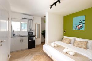 een woonkamer met een bed en een groene muur bij Localz house in Tel Aviv