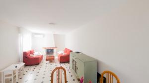 ein Wohnzimmer mit 2 roten Stühlen und einem Kamin in der Unterkunft Casa Serena in Roquetas de Mar