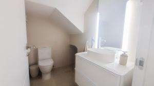 ein weißes Badezimmer mit Toilette und Waschbecken in der Unterkunft Casa Serena in Roquetas de Mar + 7 Fotos