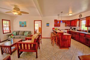 a kitchen and living room with a couch and a table at Escape Away Belize Beach House in San Pedro