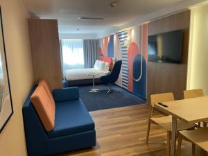 a living room with a couch and a table at Holiday Inn Express & Suites Lisbon - Príncipe Real by IHG in Lisbon +68 photos