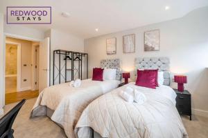a bedroom with two beds with white and red pillows at Brand New Premium Serviced Apartments, Free Parking, High-Speed WiFi By Redwood Stays in Cove +98 photos