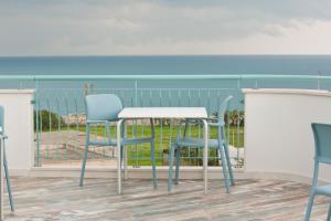 una mesa y sillas en un balcón con vistas al océano en B&B Alalama, en Polignano a Mare