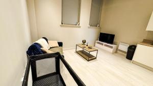 a living room with a couch and a tv at Prime Leeds- Spacious Cinema apartment in Central Station