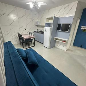 a living room with a blue couch and a kitchen at Casa Azul, Privativa, Confortável, AR, Wi-Fi in Joinville
