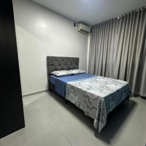 a bedroom with a bed with a blue blanket and a window at Casa Azul, Privativa, Confortável, AR, Wi-Fi in Joinville +14 photos