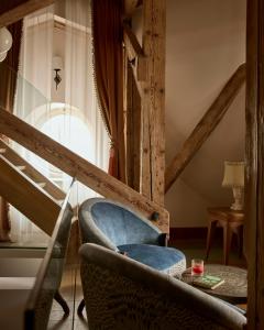 a living room with a chair and a ladder at Sir Prague, part of Sircle Collection in Prague