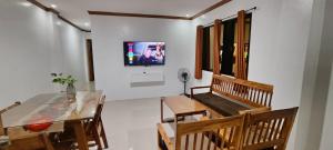 a dining room with a table and a tv on a wall at Casa Victoria Pension House-Star Maria in Somosomo +2 photos