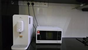 a microwave and a wii controller on a table at Andalus Homestay in Jerantut