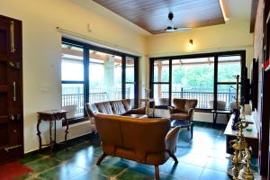 a waiting room with leather chairs and windows at Villa Vaasa Luxury Homestay in Avathi