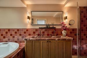 a bathroom with a tub and a sink and a mirror at Sir Prague, part of Sircle Collection in Prague