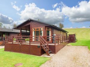 a wooden cabin with a large deck in a field at 15 Badgers Retreat - Two Dales in Richmond