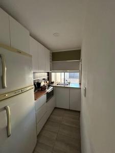 a kitchen with white cabinets and a white refrigerator at Brisas paraiso in Concepción del Uruguay