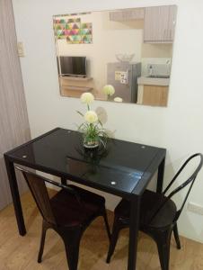 a black dining room table with two chairs and a mirror at San Remo Condo Cebu - Studio Unit in Cebu City