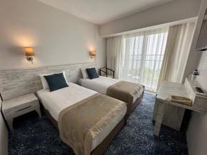 a hotel room with two beds and a window at Kırtay Hotel Erdek in Erdek +20 photos