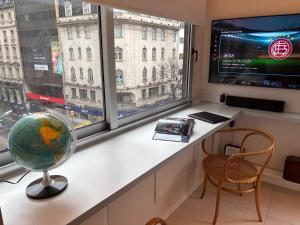 a room with a desk and a window with a television at Moderno departamento con garage para autos en el corazón de Buenos Aires in Buenos Aires