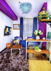 a living room with a blue couch and purple ceilings at Romantic Purple 1-Bedroom 5-8 pax in CDO in Pontud