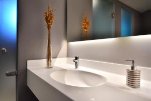a bathroom with a white sink and a mirror at Hotel Korali in Troulos