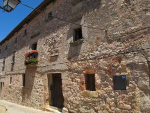 un antiguo edificio de piedra con flores en las ventanas en Casa de los Judi­os, en Sigüenza