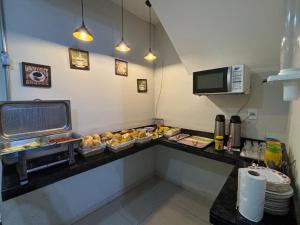 a restaurant kitchen with a counter with food on it at Pousada Mãe Padroeira in Aparecida