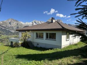 a small white house with mountains in the background at Jambo Pua in Alt Sankt Johann