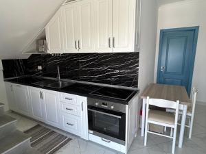 a kitchen with a stove and a sink and a table at Villa 6C Sunny Nest in Draç