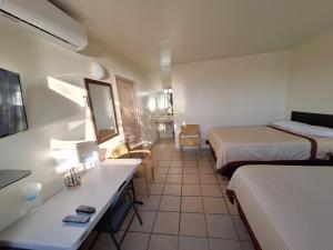 a small hotel room with two beds and a desk at #36 Bungalow Seaside Hotel & Victors RV Park in San Felipe