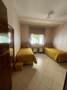 una camera da letto con due letti e una finestra di appartement Anna 2 chambres et salon balcons de avec piscine bien situé au centre de oued laou a Oued Laou Altre 27 foto