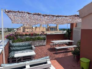 a patio with a bench and a table on a roof at Baires&Blo Ático duplex, Terraza chillout exclusiva y vistas al mar in Benicarló +42 photos