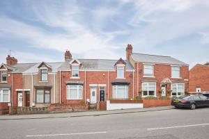 a car parked in front of a brick house at Vacant Nests The Park View Seaham Hideaway 