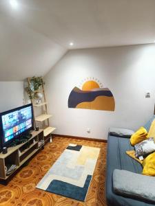 Una sala de estar con un sofá y un televisor de pantalla plana. en Escale Secrète Détente Montargis Parking Gratuit, en Montargis