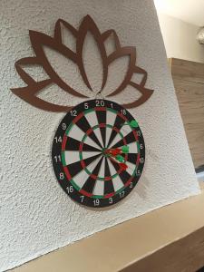 Un tablero de dardos en una pared con una flor encima. en Escale Secrète Détente Montargis Parking Gratuit, en Montargis 40 fotos más