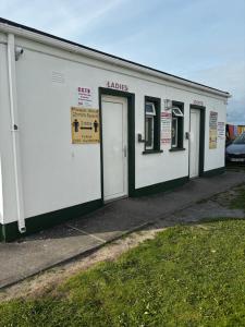 a white building with four doors on it at Glamping Pod in Milltown Malbay