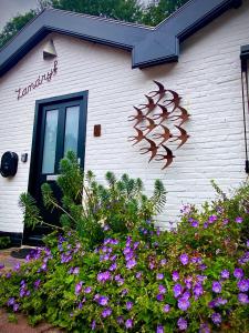 a house with a sign on the side of it with purple flowers at Zandrijk in Egmond aan den Hoef +17 photos