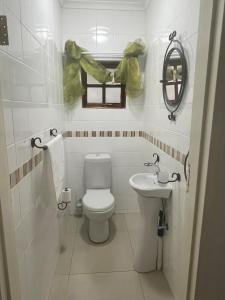 a white bathroom with a toilet and a sink at La Mia casa in Gaborone +45 photos