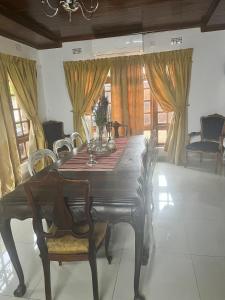 a dining room with a wooden table and chairs at La Mia casa in Gaborone