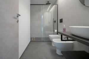 a bathroom with two toilets and a sink and a shower at Room 52 - stanza da sogno in Biella