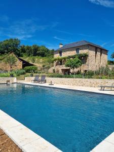 una piscina con una casa al fondo en Les Peyronnies, en Figeac