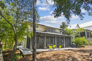a large house with a porch with yellow chairs at LunaSea by 30A Escapes in Seagrove Beach +29 photos