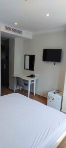 a bedroom with a bed and a desk with a computer at Hotel BLADOR in Tichi