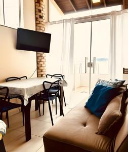 una sala de estar con un sofá y una mesa en 01 - Apto Pé na Areia - Sacada na Praia, en Palhoça