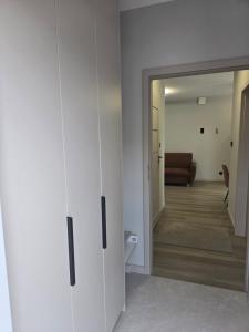 a room with white cabinets and a living room at Hotel-24 in Płock