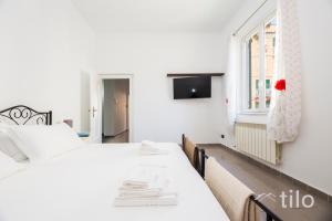 a white bedroom with two beds and a window at Airport 8 Minutes, 2BR, Terrace, By Tilo in Genova