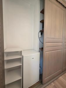 a closet with a white refrigerator and shelves at Chambre Cosy & Vintage - Wifi - TV in Bracquemont