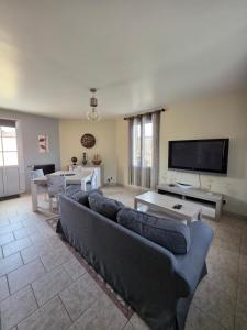 a living room with couches and a flat screen tv at Chambre Cosy & Vintage - Wifi - TV in Bracquemont