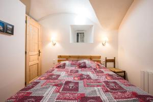 Saint-Colomban-des-VillardsにあるBreizh Chalet - 6 personnesのベッドルーム(キルト付きのベッド付)