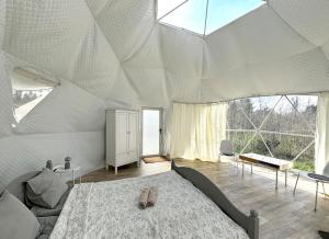 a bedroom with a large bed and a large window at Bubble House glamping telk in Sõmeru