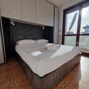 a large bed with white sheets and pillows in a bedroom at Appartamento King a Gattatico Centro in Praticello di Gattatico