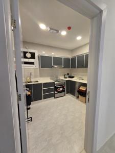 a kitchen with black and white cabinets and appliances at Luxury Furnished Apartment in Salalah Center in Salalah